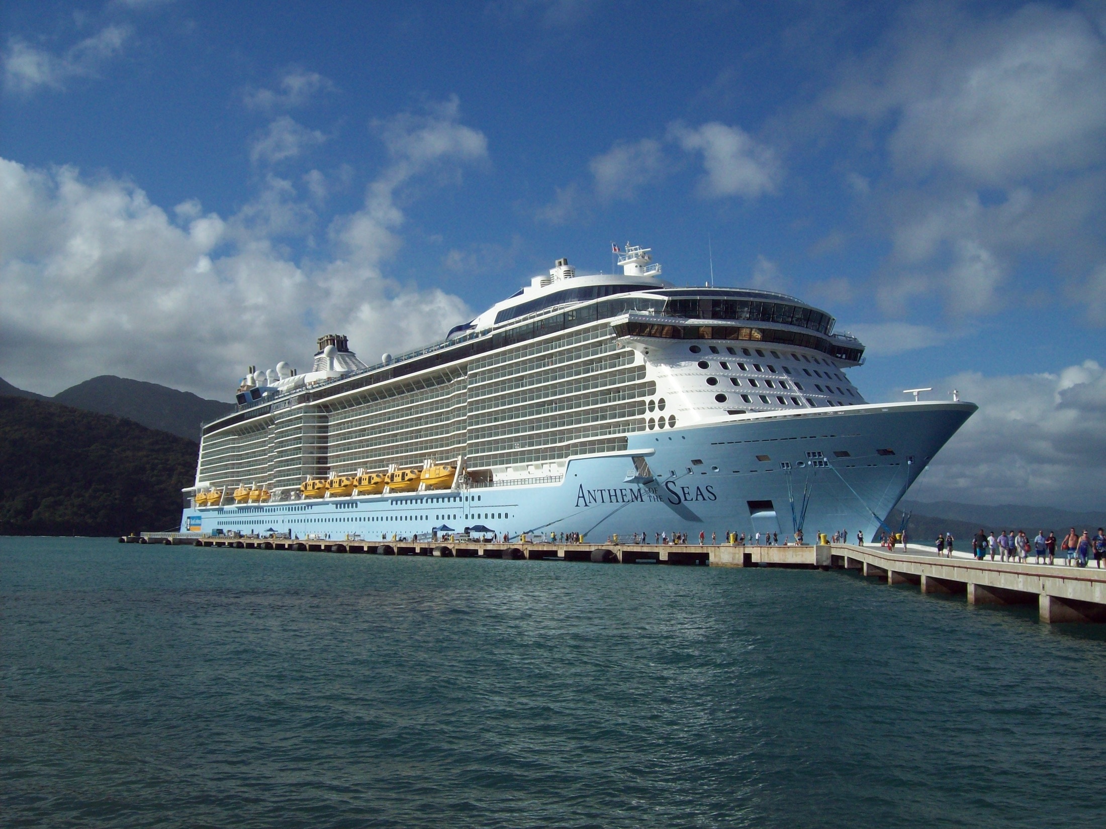 Anthem of the Seas docked at a tropical cruise port.